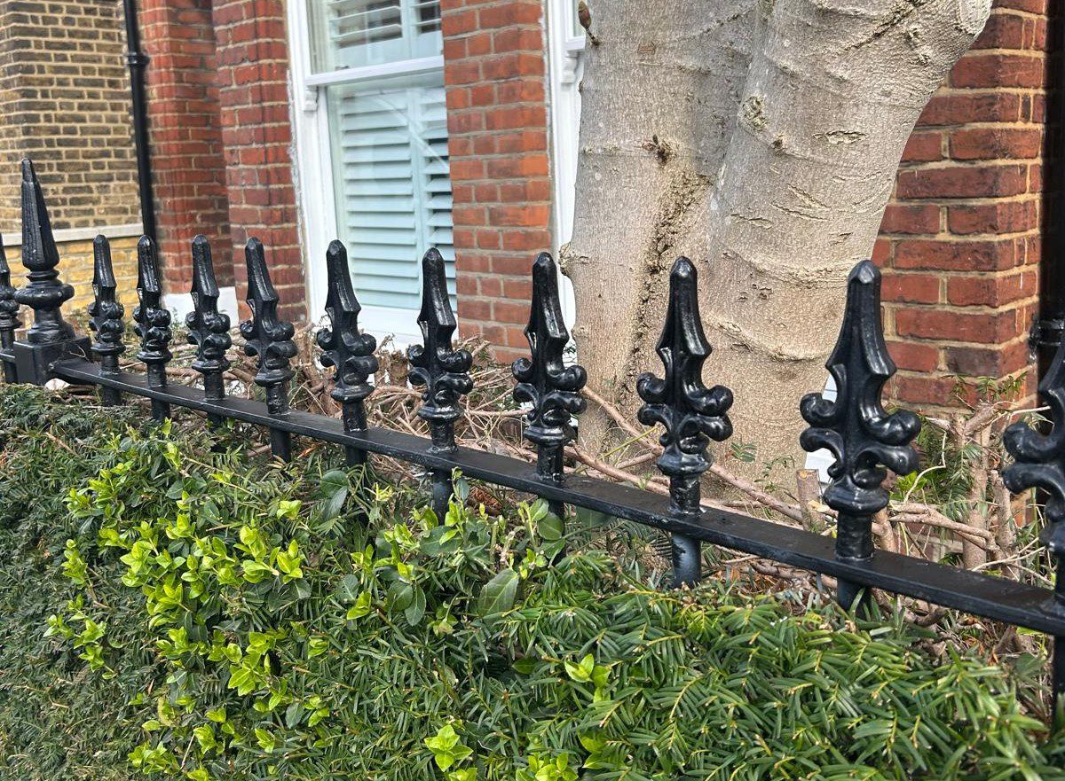 Replacement cast iron finials installed and painted on period railings, Battersea London SW11